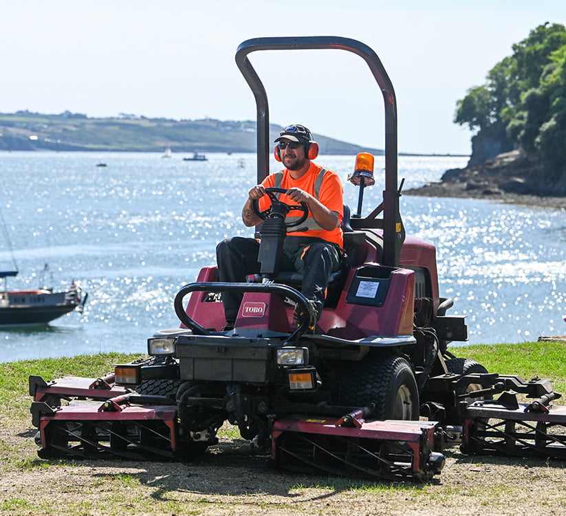 arborcure employee in hi vis carrying out grounds maintenance